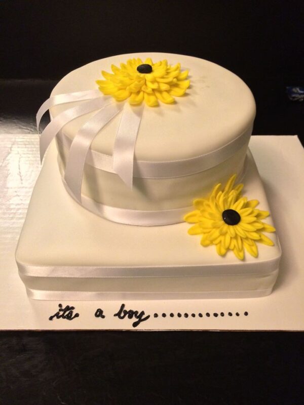 A white cake with yellow flowers on it.