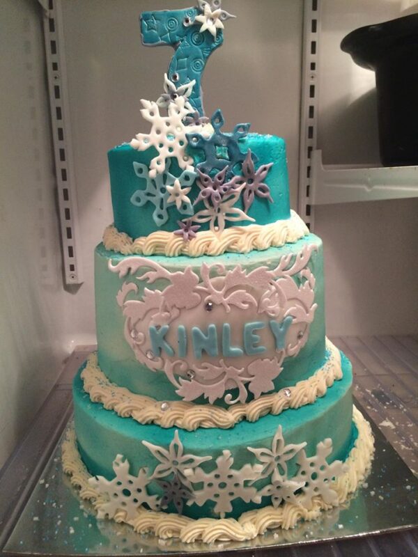 A blue and white cake with snowflakes on it.