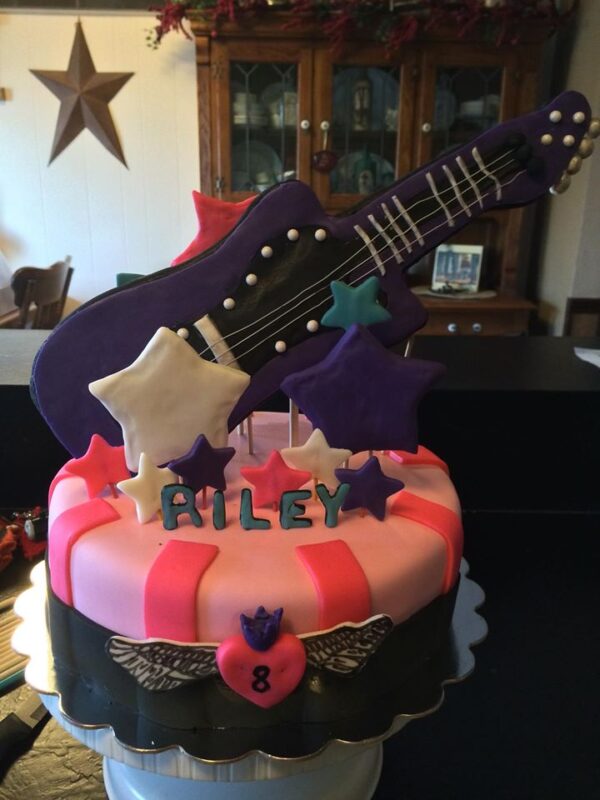 A cake decorated with a guitar and stars.