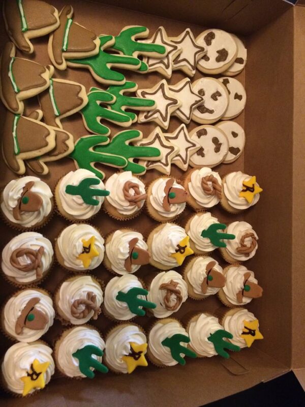 A box of cookies decorated with cactus and stars.