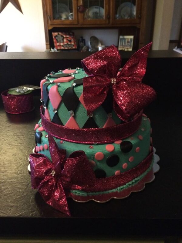 A cake with polka dots and pink bows.