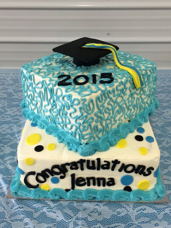 A cake with a graduation cap and hat on top.