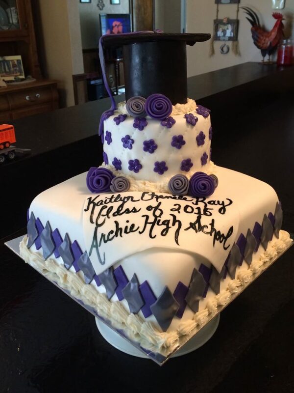 A square cake with a graduation hat on top.