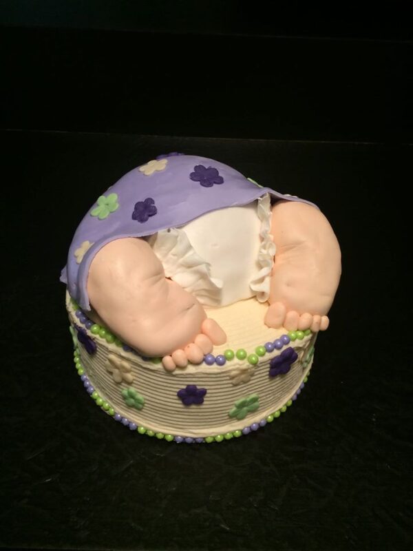 A cake with a baby's feet in it.