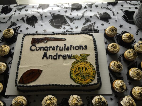 A cake with cupcakes and a gun on it.