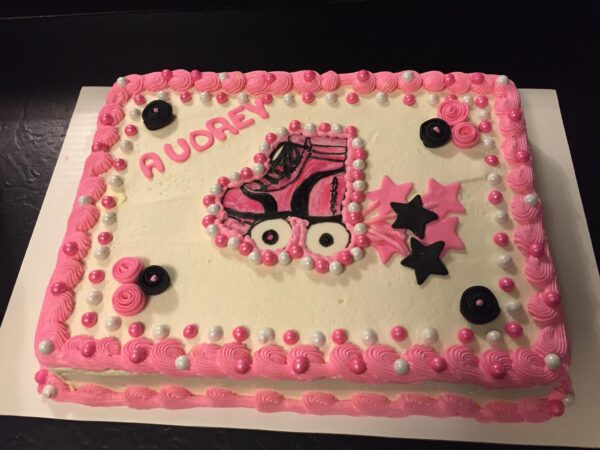 A pink cake with a skateboard on it.