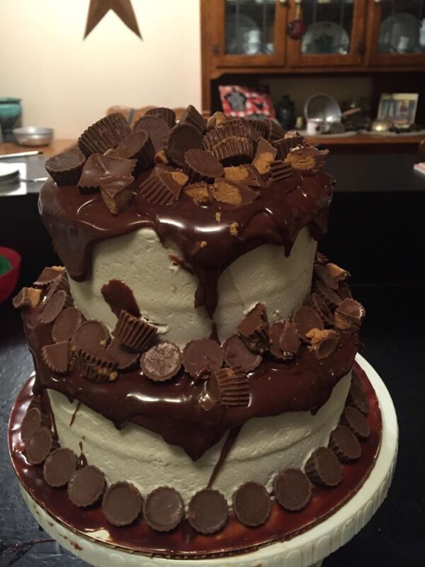 A chocolate cake topped with peanut butter cups.