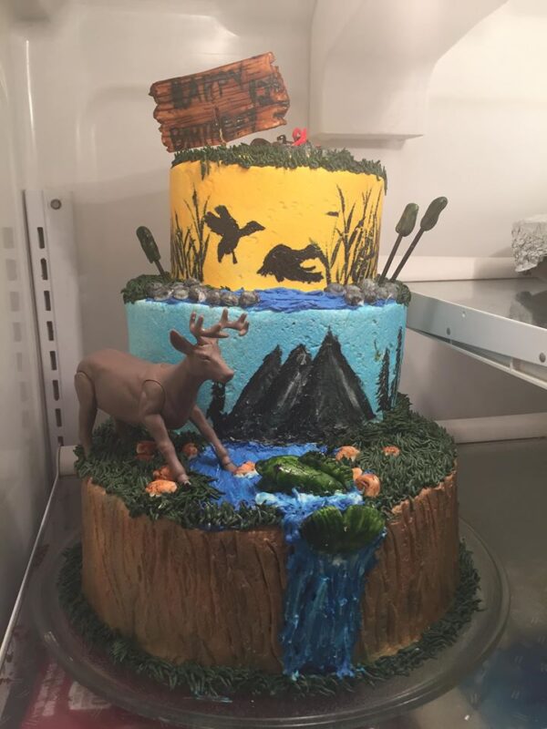 A three tier cake with a deer on top.