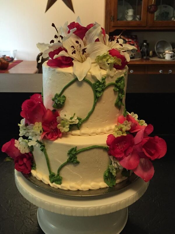 A white cake with pink flowers on top.