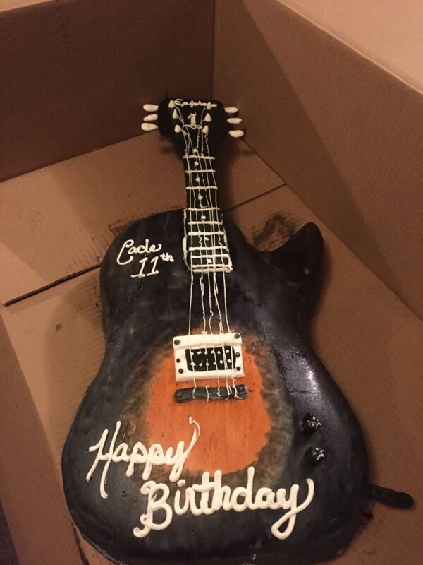 A cake that looks like a guitar.