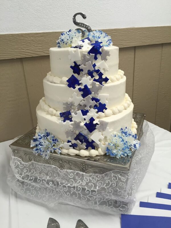 A white and blue wedding cake on a table.