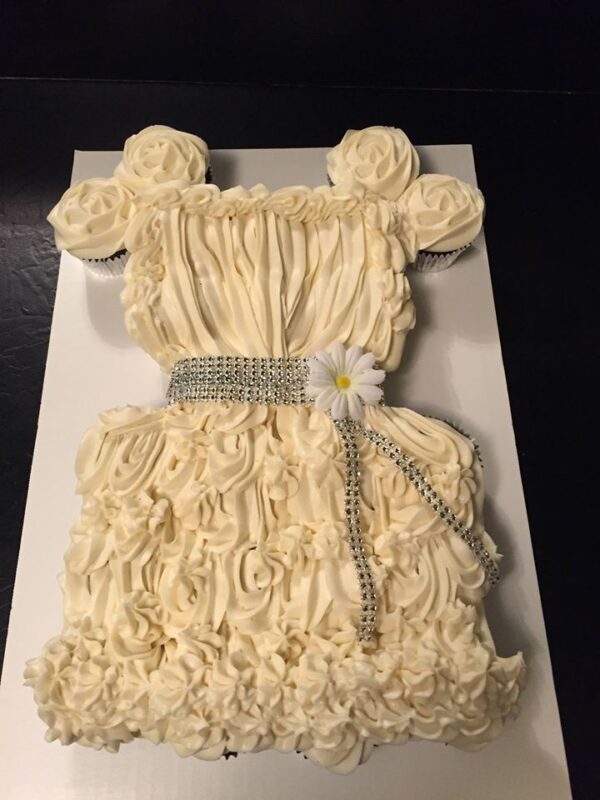 A cake with a white dress on it.