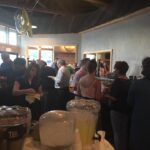 A group of people standing around a table in a restaurant.