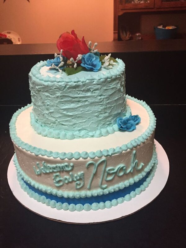 A blue and white cake with roses on top.