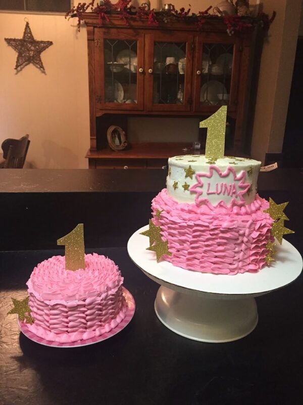 A pink cake with a gold star on top.