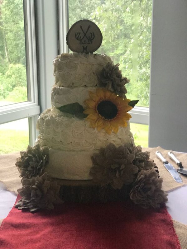 A wedding cake with sunflowers on top.