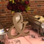 A table with a pink tablecloth and a bouquet of flowers.