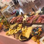 A pink table with a variety of food on it.