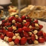 A plate of tomatoes and cheese on skewers.