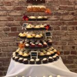 A three tiered cake stand with cupcakes on it.