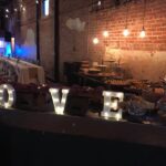 A table with a sign that says love in front of a brick wall.