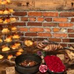 A display of pastries and desserts on a brick wall.