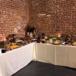 A buffet set up in front of a brick wall.