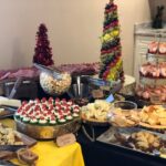 A buffet table with a variety of foods and desserts.