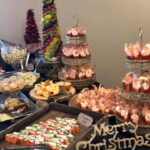 A table full of snacks and desserts for a christmas party.