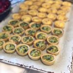 A tray of mini quiches on a table.