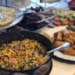 A buffet table with a variety of food on it.