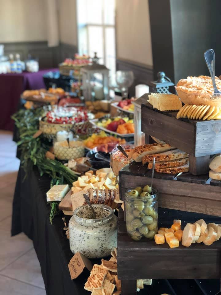 A buffet table with a variety of cheeses and crackers.