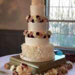 A three tier wedding cake is sitting on top of a table.