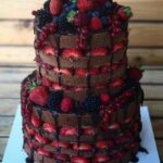 A Tiered Cakes with strawberries and berries on top.