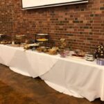 A buffet table set up in a room with a brick wall.