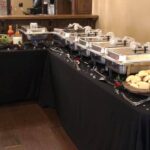 A buffet table with a variety of food on it.