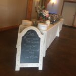 A table with food and a chalkboard sign.