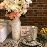 A table with flowers and silverware on it.