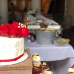 A white cake with red roses on top.