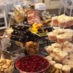 A table full of desserts and cupcakes at a wedding.