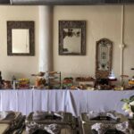 A buffet is set up in a room with mirrors.