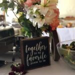 A table with flowers and a sign that says together is my favorite.