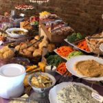 A buffet table with a variety of food on it.