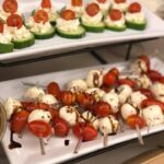 A tray of skewers with tomatoes, cucumbers, and mozzarella.