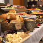 A buffet with a variety of breads and cheeses.