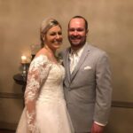 A bride and groom posing for a picture in a room.