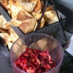 A bowl of chips and salsa on a table.