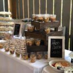 A table full of food and desserts at a wedding.