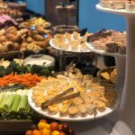 A buffet with a variety of food on trays.