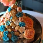 A cake decorated with blue and orange flowers.